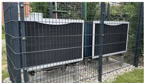 Due unità esterne protette da una recinzione in un giardino